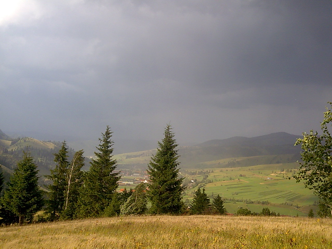 Gyimesfelsőlok házai és a környező zöld hegyoldalak az Őrhegyről nézve